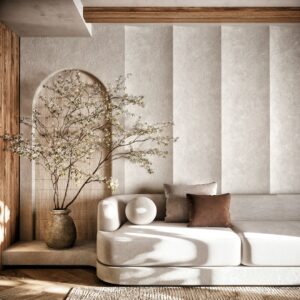 Beige sectional sofa with brown and beige cushions beside a tall vase with flowering branches in a sunlit modern living room.