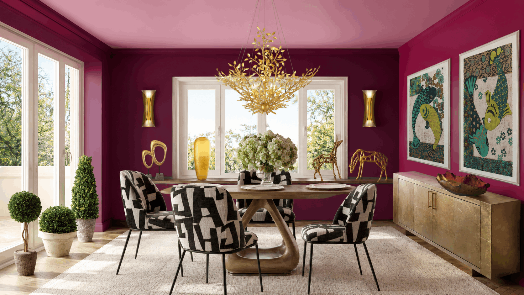 Magenta-walled dining room with a gold chandelier, round wooden table, and black-and-white patterned chairs.